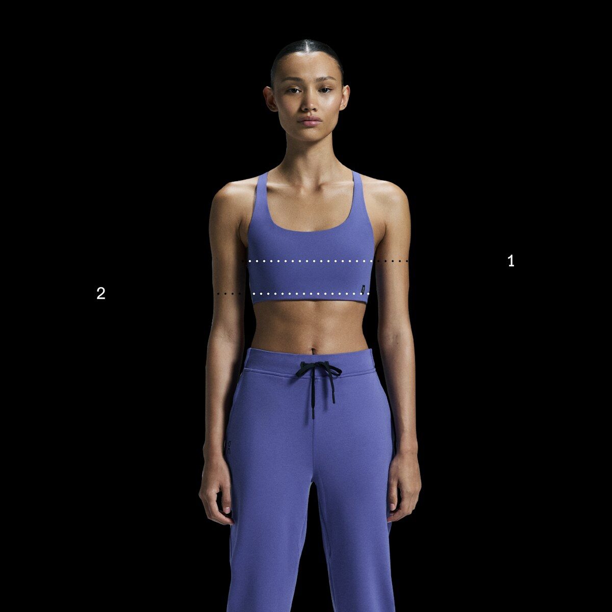 Woman in purple athletic wear against black background
